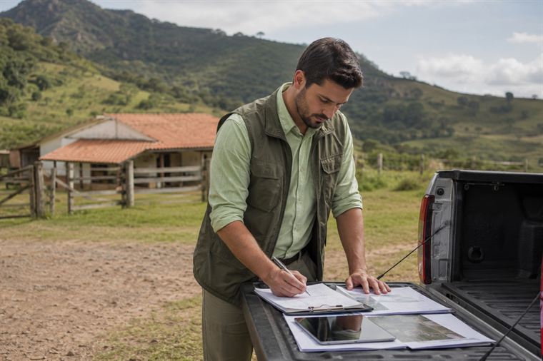 Técnico elaborando laudo de avaliação de imóvel rural no local